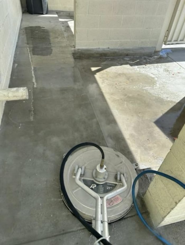 Surface cleaner working an enclosure slab β cleaned concrete meeting the remaining buildup