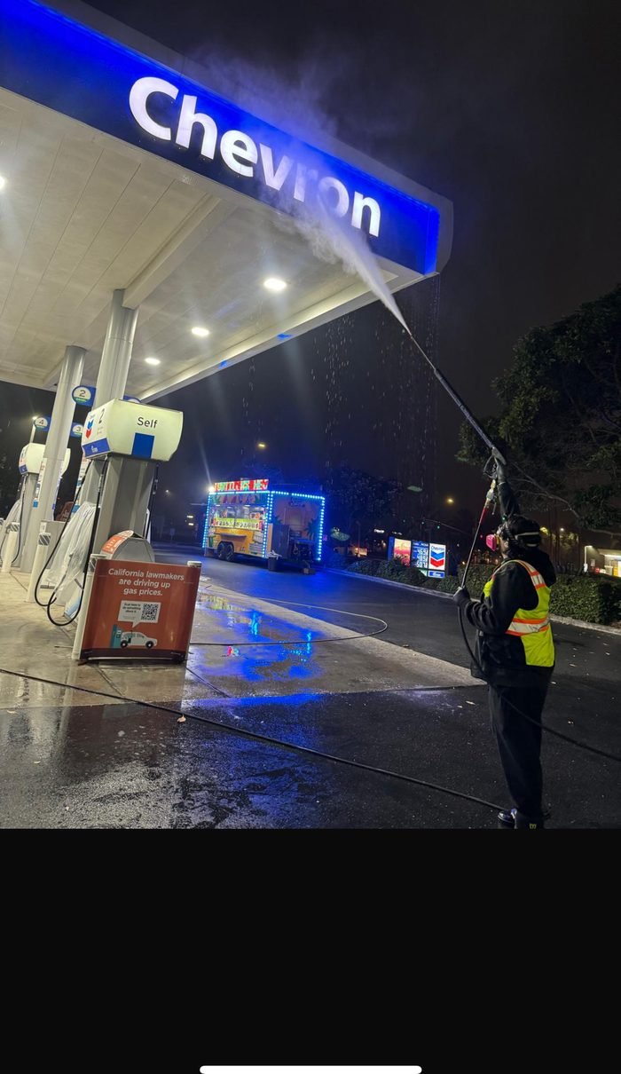 Fuel-station canopy being washed at night