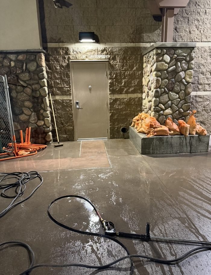Service entrance and loading-area concrete washed down, wash water controlled at the door line