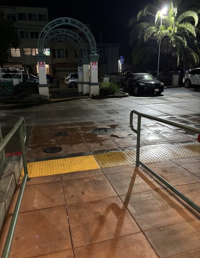 Plaza tile, railings, and tactile ADA paving washed at a mixed-use property