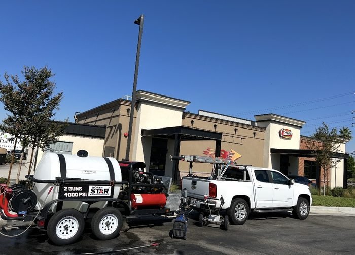 Quick-service restaurant drive-thru and lot service β hot-water rig on site in daylight