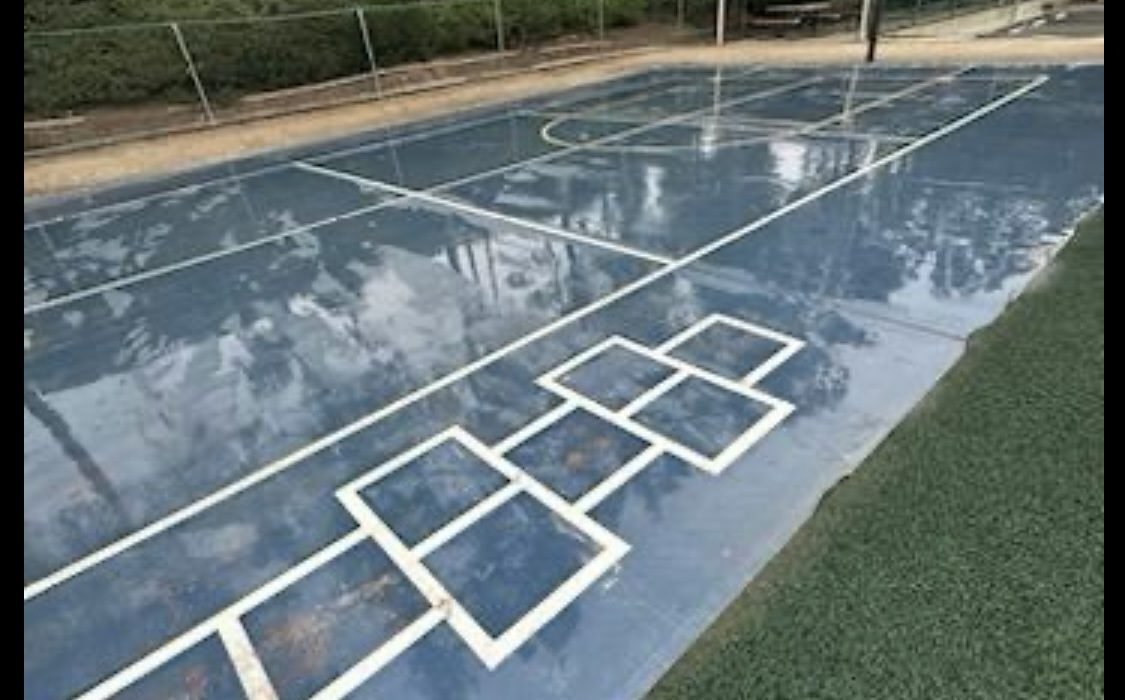 Blue sports court pressure washed clean — hopscotch and basketball surfaces at a Southern California community recreation area